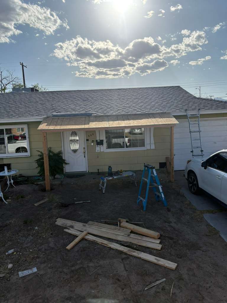 Before — bare framing and a dirt yard, no porch shade