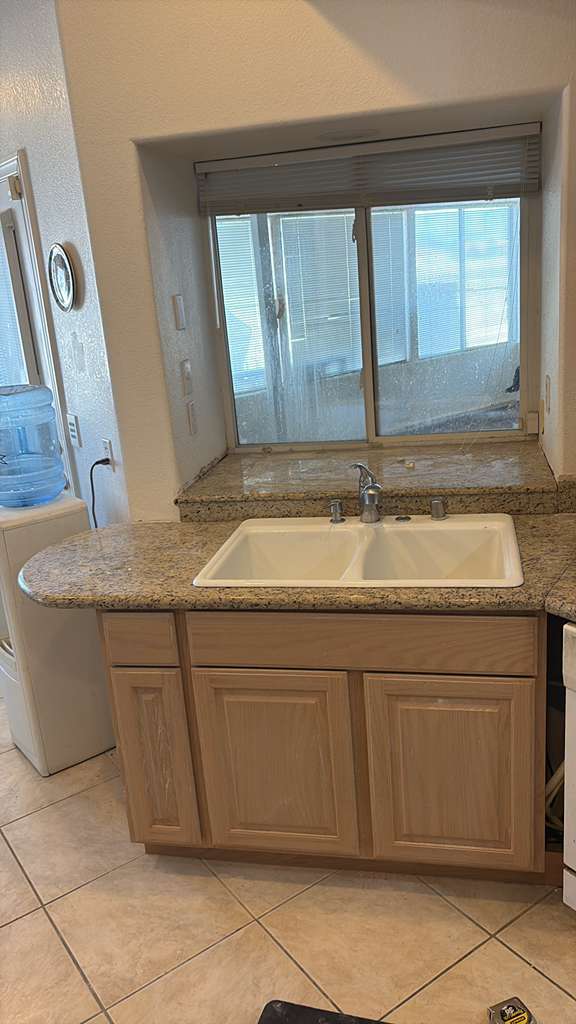 After — new kitchen base cabinet, granite counter and double sink installed