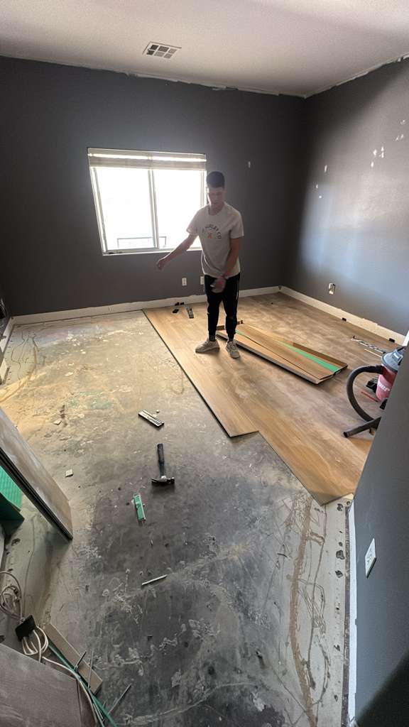 Laying new vinyl plank flooring during a room remodel in Las Vegas
