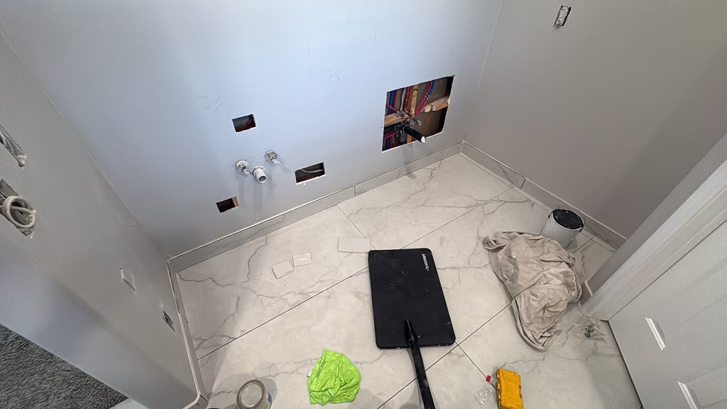 Bathroom remodel progress — new marble-look tile floor and plumbing rough-in, Las Vegas