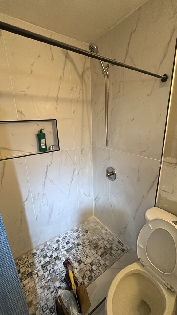 Finished marble-tile walk-in shower with mosaic floor and built-in niche in Las Vegas