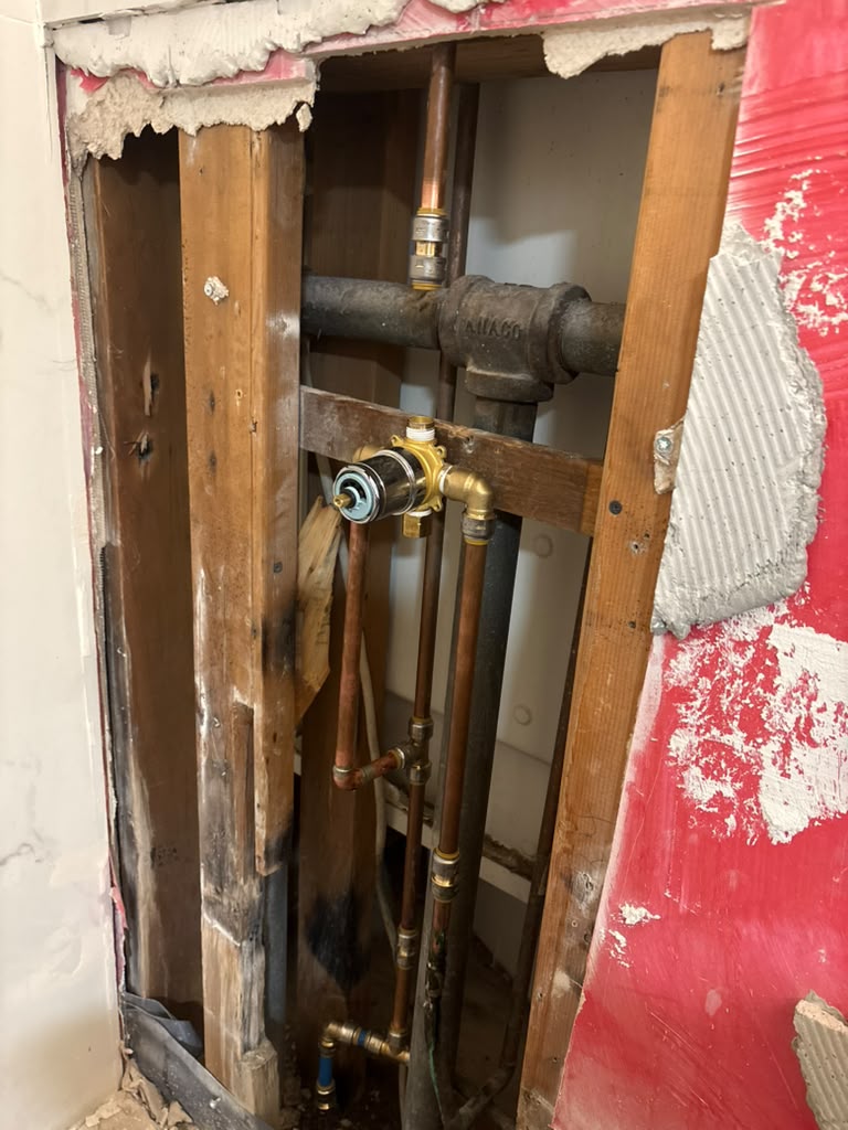 New shower mixing valve and copper supply lines roughed in behind an open wall in Las Vegas