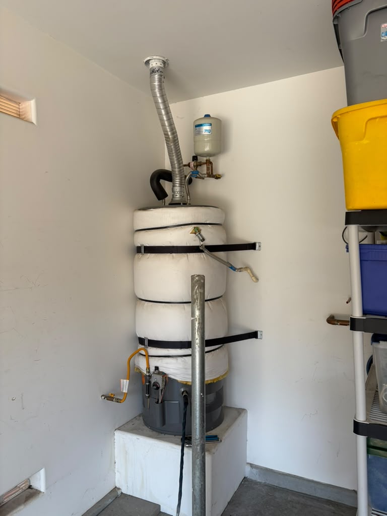 Water heater fitted with an insulation blanket and seismic straps in a Las Vegas garage