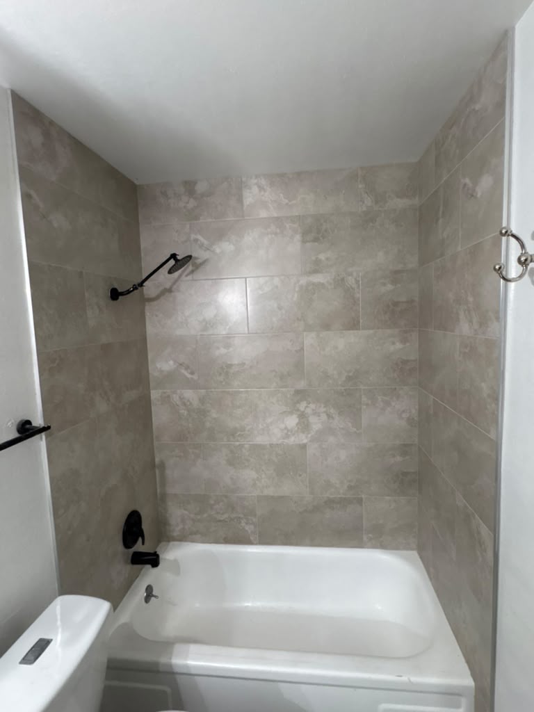 New tub with rain shower head and matte black trim in a Las Vegas bathroom remodel