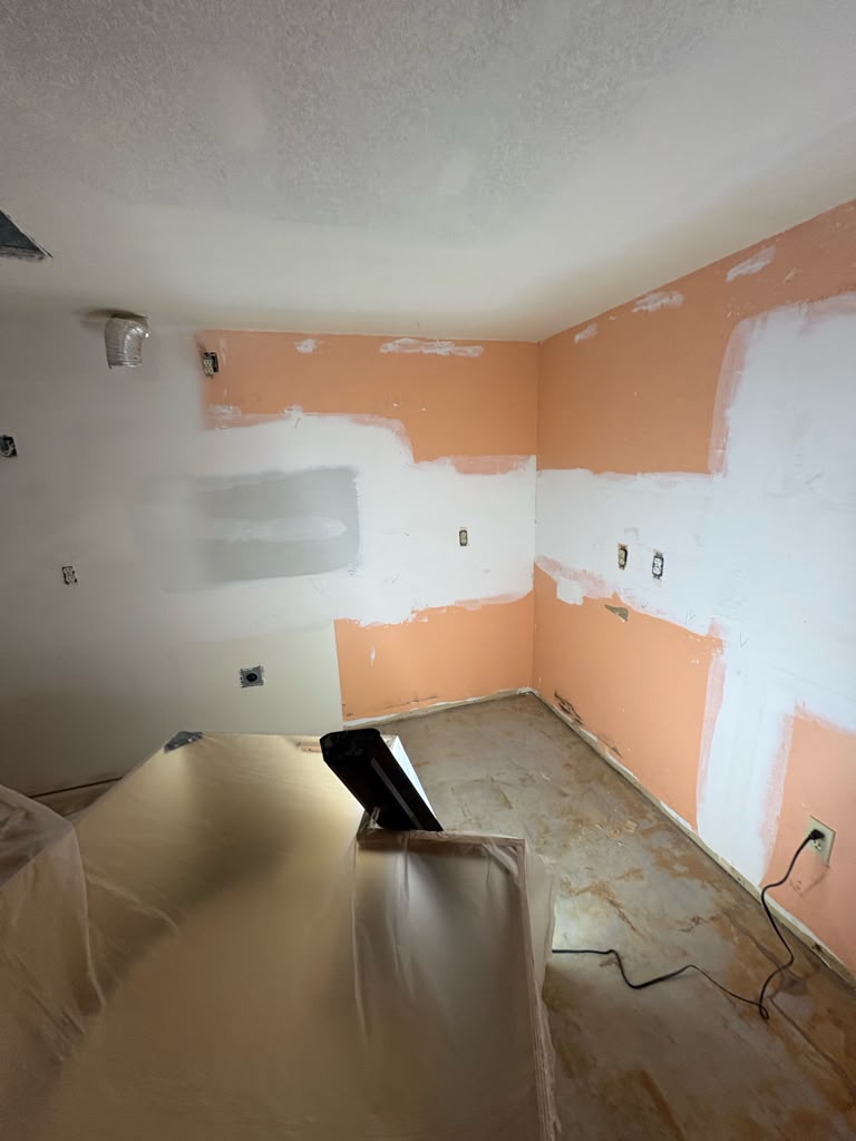 Half skim-coated kitchen walls with cabinets protected under plastic in Las Vegas
