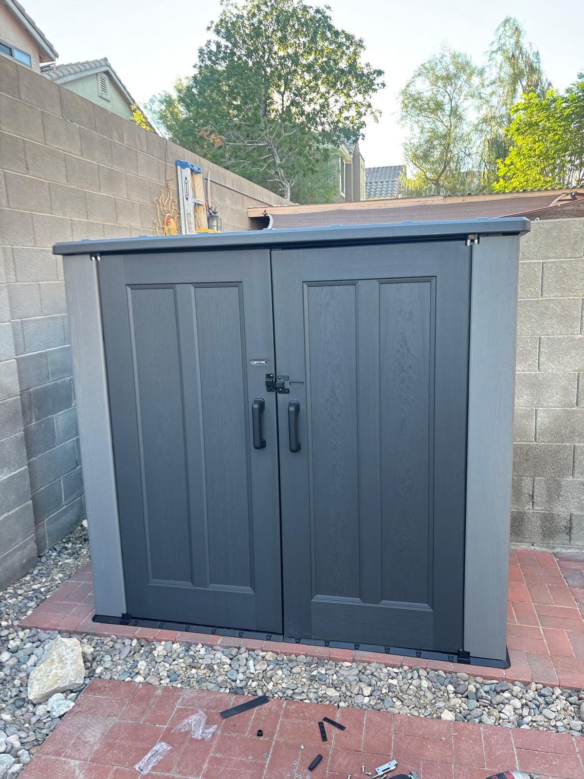 New storage shed assembled and set on a paver pad in a Las Vegas backyard